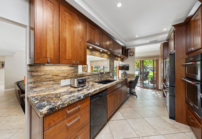 Chef's kitchen with granite counters and wood cabinetry